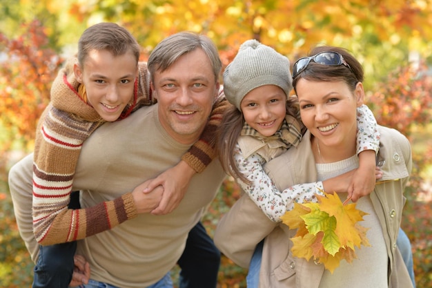 Heureuse jeune famille se reposant dans le parc d'automne