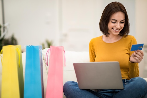 Heureuse jeune femme accro du shopping à la maison