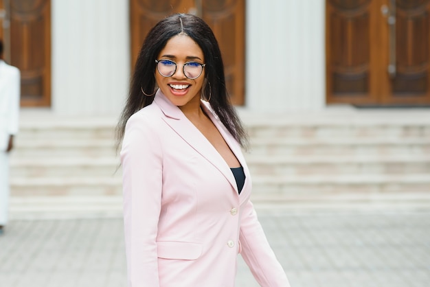 Heureuse jeune femme d'affaires afro-américaine en ville