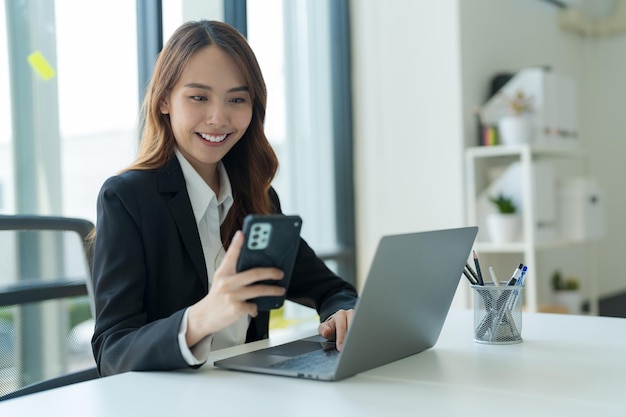 Heureuse jeune femme d'affaires asiatique portant un costume