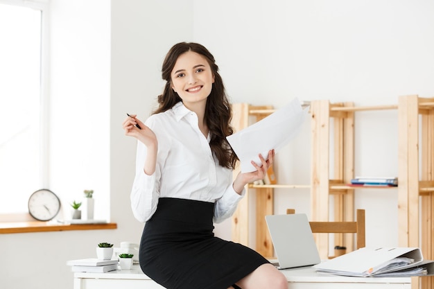 Heureuse Jeune Femme D'affaires Ou Secrétaire Tenant Un Document Dans Un Bureau Moderne