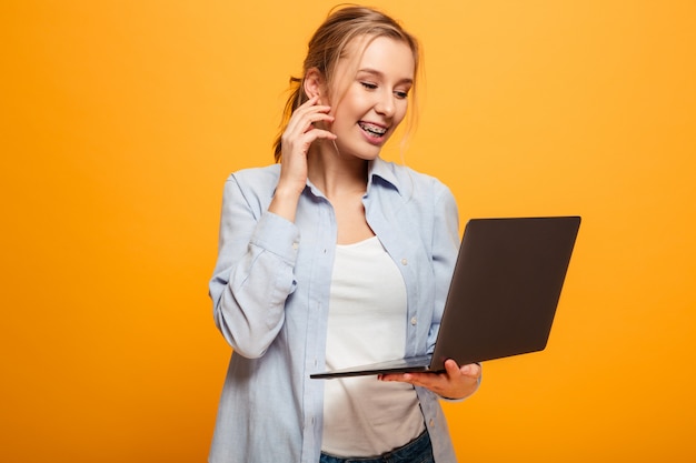 Heureuse jeune femme à l'aide d'un ordinateur portable.