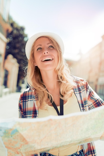 Photo heureuse jeune femme à l'aide d'un plan de la ville