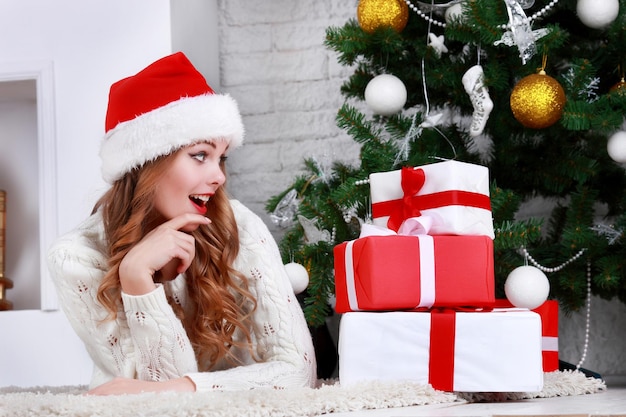 Heureuse jeune femme allongée sur le sol avec boîte-cadeau de noël