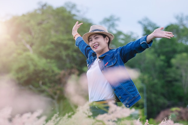 Heureuse jeune femme asiatique assise sur un terrain d&#39;herbe