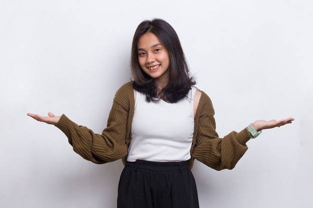 Heureuse jeune femme asiatique pointant du doigt vers différentes directions isolées sur fond blanc