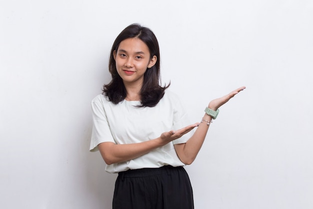 Heureuse jeune femme asiatique pointant du doigt vers différentes directions isolées sur fond blanc