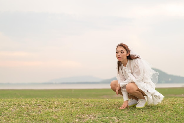 Heureuse jeune femme asiatique en tenue de mariée avec voile