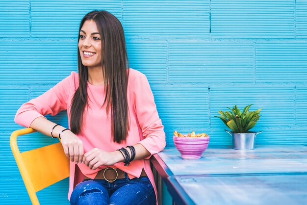 Heureuse jeune femme assise dans un restaurant