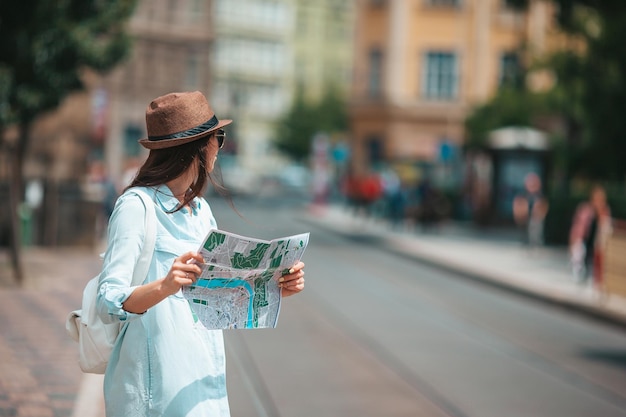 Heureuse jeune femme au chapeau dans la rue de la ville européenne