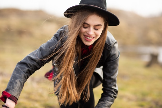 Heureuse jeune femme au chapeau noir