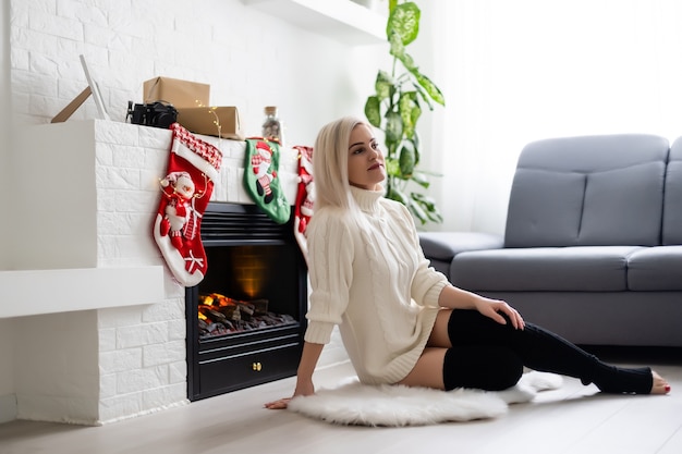 Heureuse jeune femme au coin du feu. Notion de nouvel an de Noël.