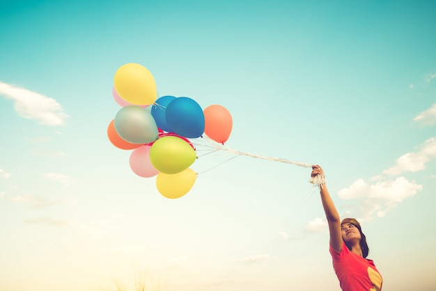 Heureuse jeune femme avec des ballons colorés