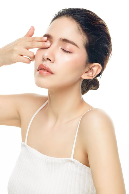 Heureuse jeune femme avec un beau visage avec une peau fraîche et propre parfaite sur fond blanc