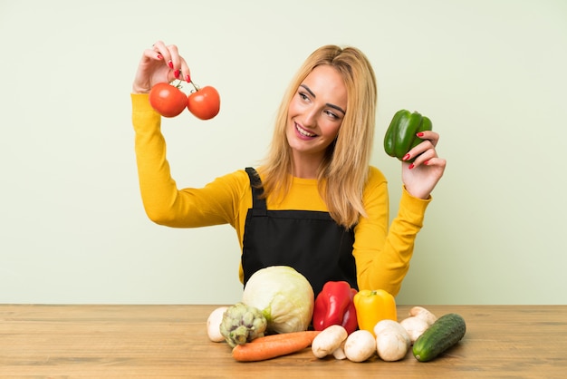 Heureuse jeune femme blonde avec beaucoup de légumes