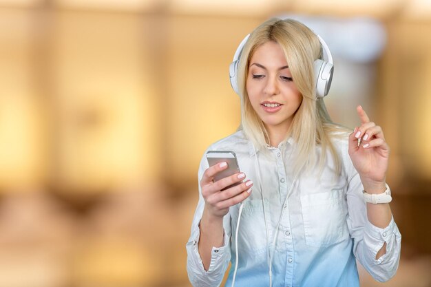 Heureuse jeune femme blonde écoutant de la musique