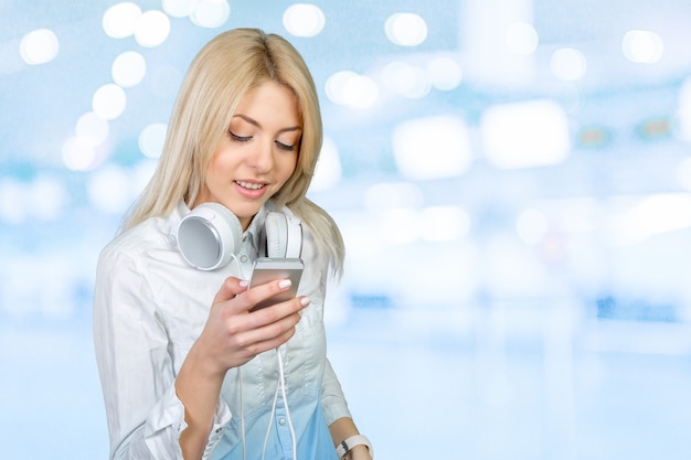 Heureuse jeune femme blonde écoutant de la musique