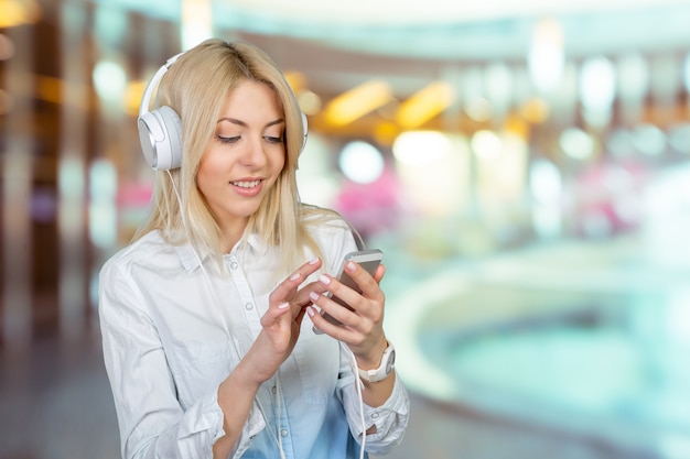 Heureuse jeune femme blonde, écouter de la musique