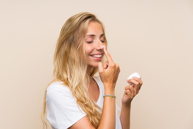 Heureuse jeune femme blonde avec un hydratant