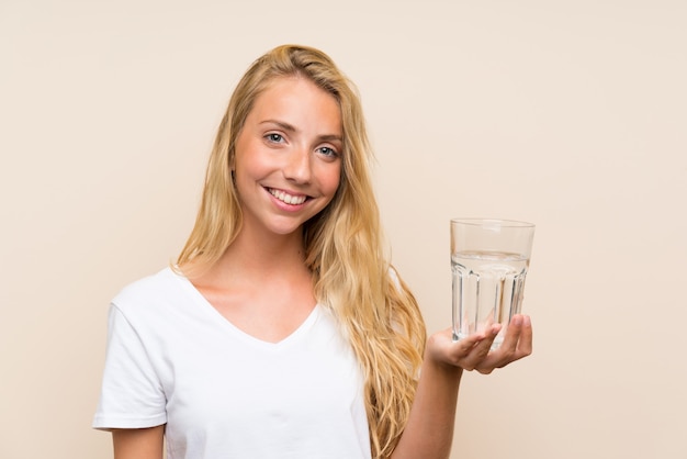 Heureuse jeune femme blonde avec un verre d'eau