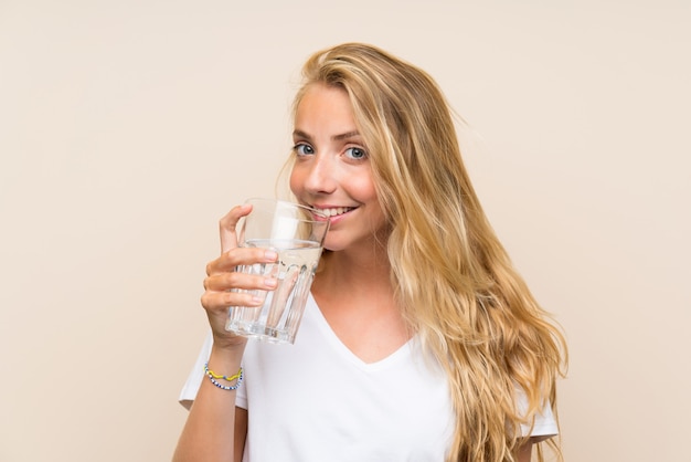 Heureuse jeune femme blonde avec un verre d'eau