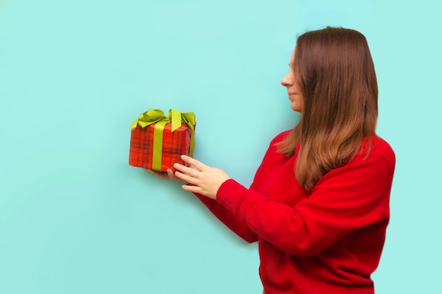 Heureuse jeune femme avec un cadeau de Noël