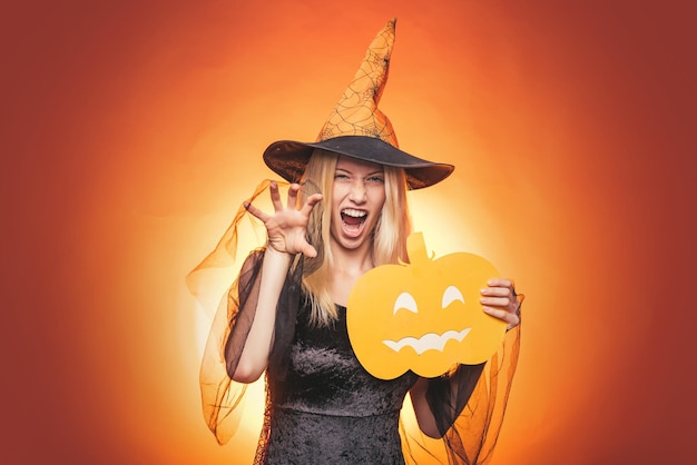 Heureuse jeune femme en costume d'halloween de sorcière sur la fête sur fond isolé Émotionnelle jeune femme en costume d'halloween sur la fête d'halloween sur fond blanc