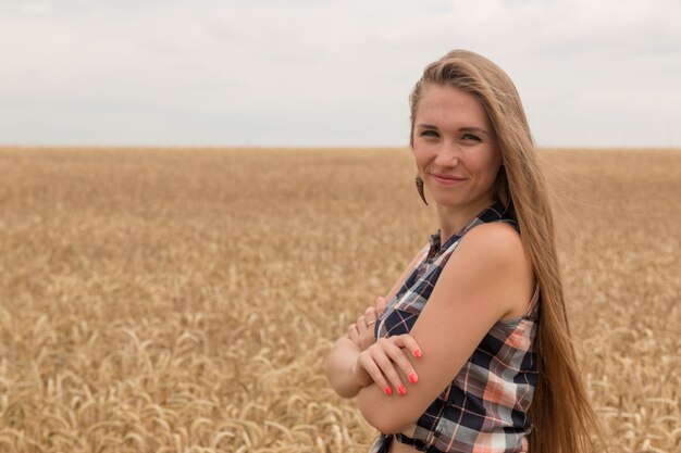 Heureuse jeune femme dans le champ de blé doré