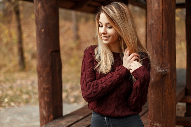 Heureuse jeune femme drôle dans un pull vintage tricoté à l'extérieur