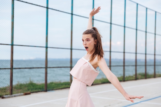 Heureuse jeune femme étonnée en équilibre et s'amuser en plein air