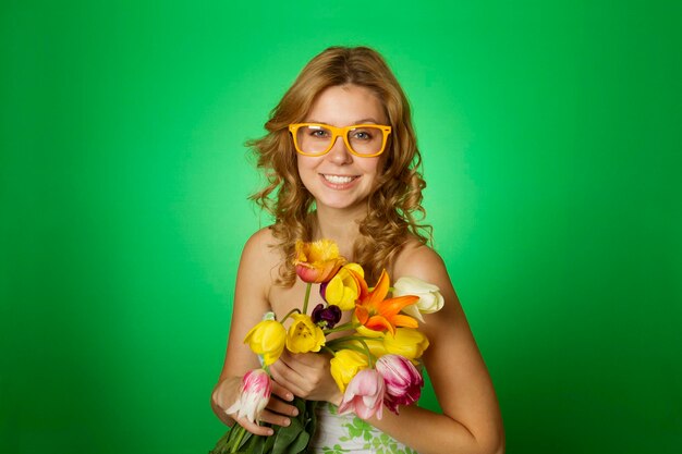 Heureuse jeune femme étreignant un bouquet de tulipes