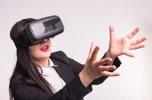 Heureuse jeune femme excitée à l'aide d'un casque de réalité virtuelle sur blanc