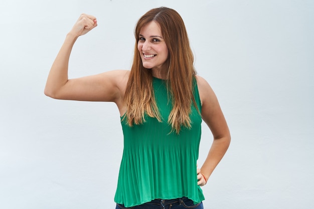 Heureuse jeune femme faisant le geste de force isolé sur fond blanc.