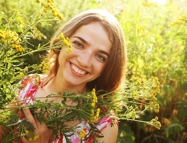 Heureuse jeune femme et fleurs sauvages.