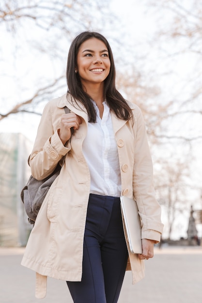 Heureuse jeune femme habillée en manteau d'automne