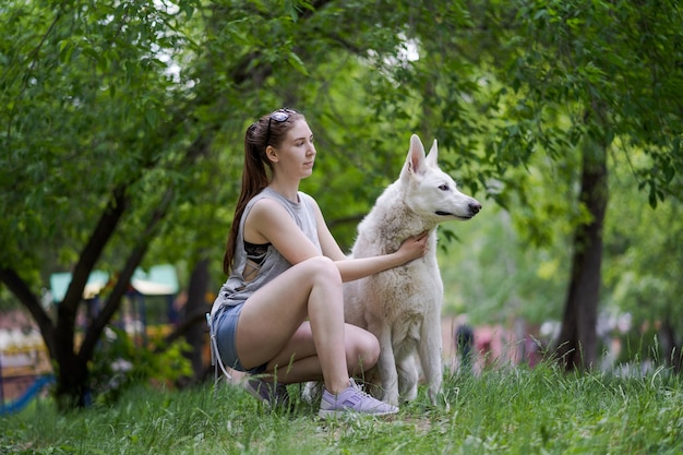 Heureuse jeune femme jogging avec son chien dans le parc.