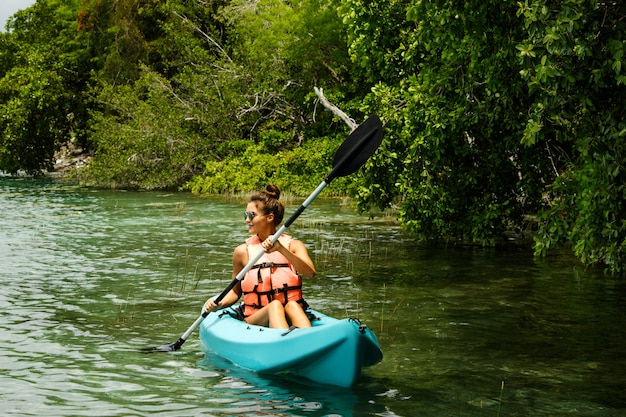 Heureuse jeune femme en kayak sur le lac