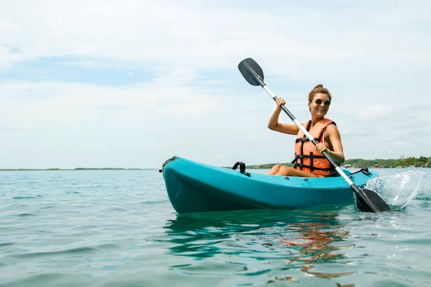 Heureuse jeune femme en kayak sur le lac