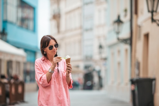 Heureuse jeune femme mangeant des glaces Voyage en Europe Femme touristique de voyage à l'extérieur pendant les vacances en Europe