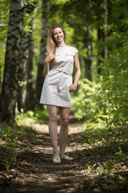 Heureuse jeune femme marchant dans le parc d'été