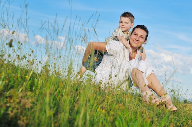 heureuse jeune femme mère jouer et en plein air avec un bel enfant