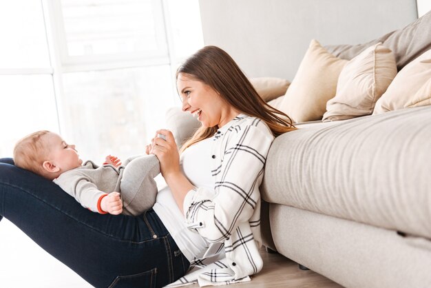 Heureuse jeune femme mère s'amusant avec son petit fils