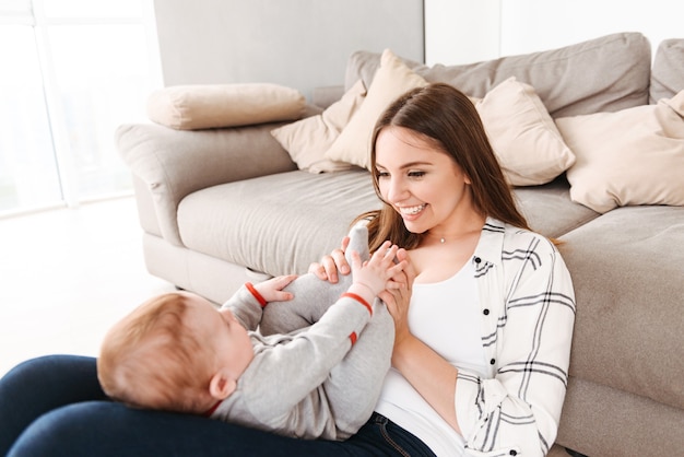 Heureuse jeune femme mère s'amusant avec son petit fils