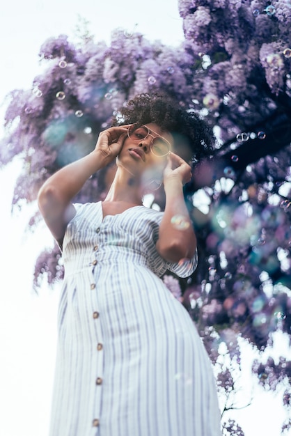 Heureuse jeune femme noire entourée de fleurs