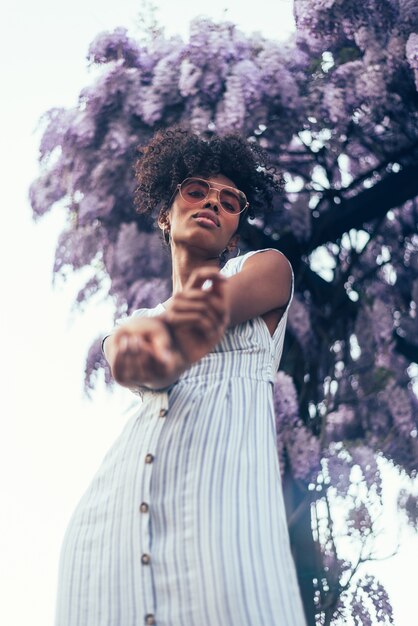 Heureuse jeune femme noire entourée de fleurs