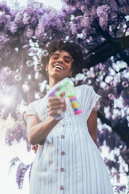 Heureuse jeune femme noire entourée de fleurs