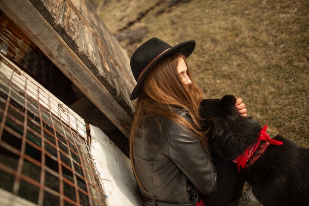 Heureuse jeune femme plaing avec son chien noir