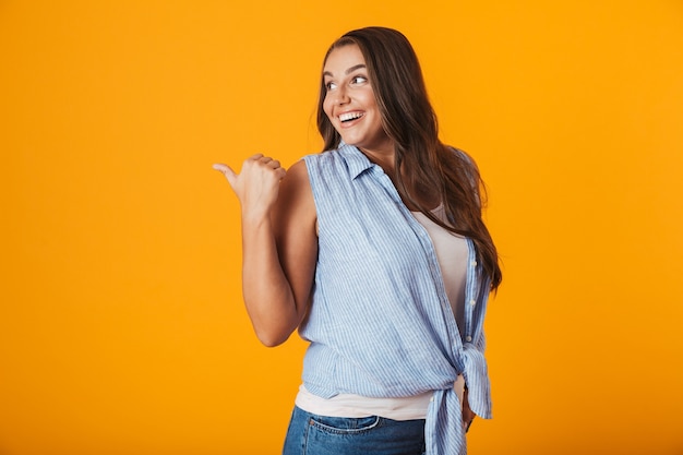 Heureuse jeune femme, pointant le doigt loin