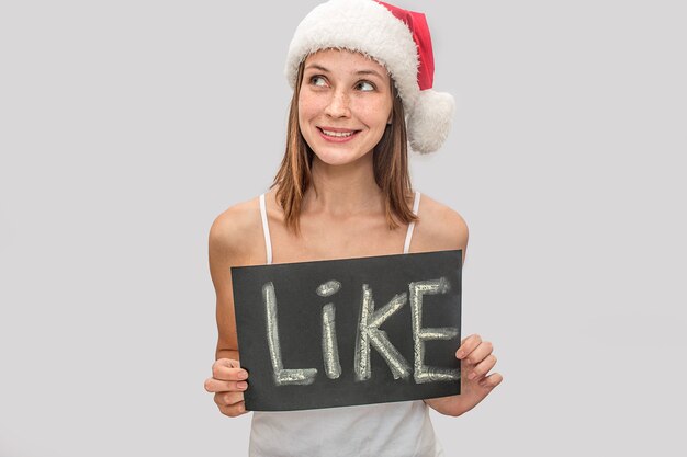 Heureuse jeune femme porte un chapeau de Noël