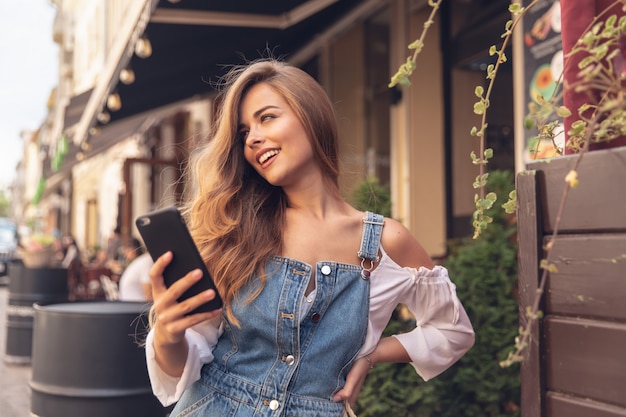 Heureuse jeune femme prenant selfie. Photo de selfie femme takig avec un smarphone dans la ville